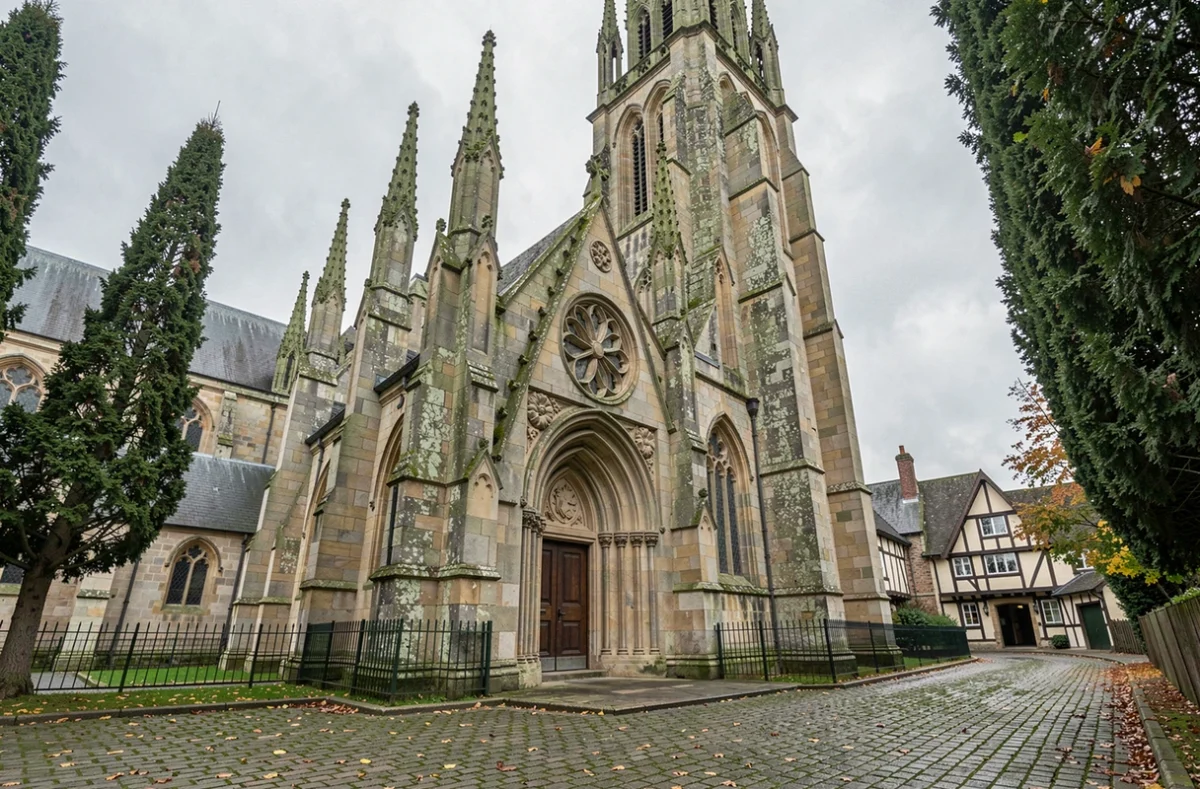 Façade gothique d'une cathédrale anglaise avec des ornements en rose Tudor sculptés dans la pierre, symbole de l'héritage religieux d'Henri VIII